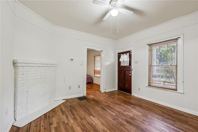 entrance foyer featuring a ceiling fan, ornamental molding, wood finished floors, and baseboards