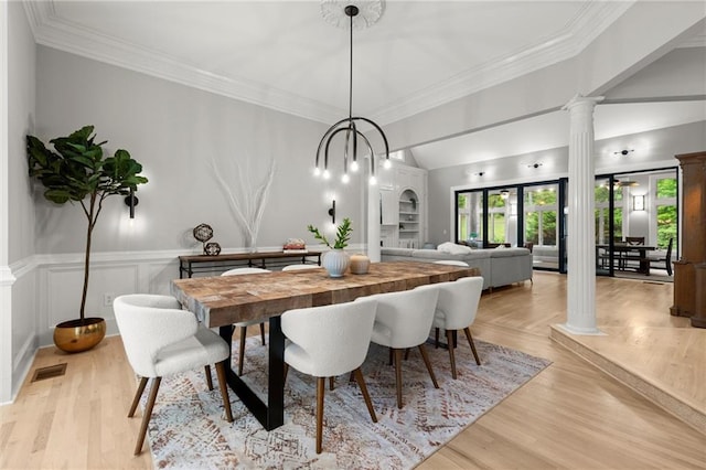 dining area featuring light wood-type flooring, crown molding, visible vents, vaulted ceiling, and ornate columns