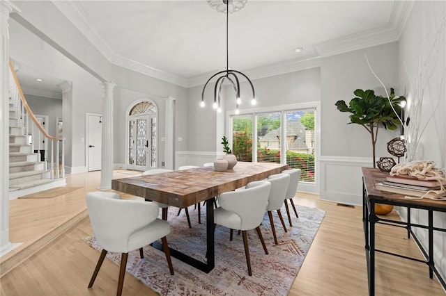 dining space featuring ornate columns, light wood-type flooring, and plenty of natural light