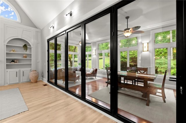 doorway to outside featuring lofted ceiling, wood finished floors, ceiling fan, and built in features