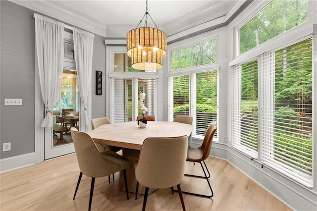 dining area featuring ornamental molding, an inviting chandelier, baseboards, and light wood-type flooring