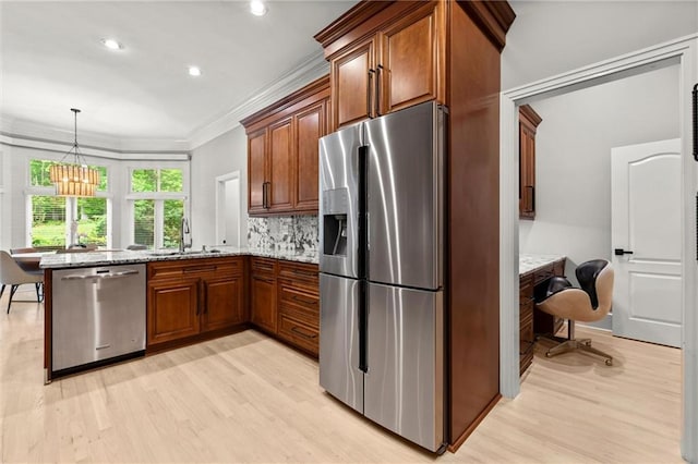 kitchen with light stone countertops, a sink, stainless steel appliances, light wood-type flooring, and a peninsula