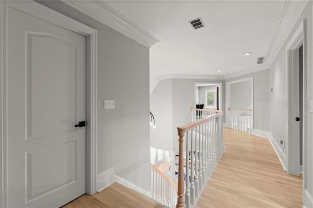 hall featuring ornamental molding, an upstairs landing, visible vents, and light wood-type flooring
