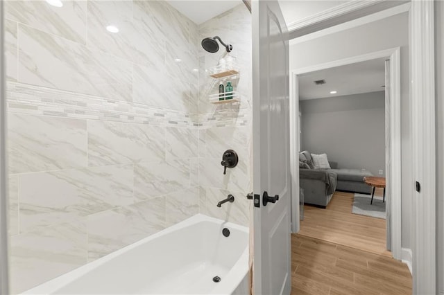 full bath with visible vents, washtub / shower combination, and wood finished floors