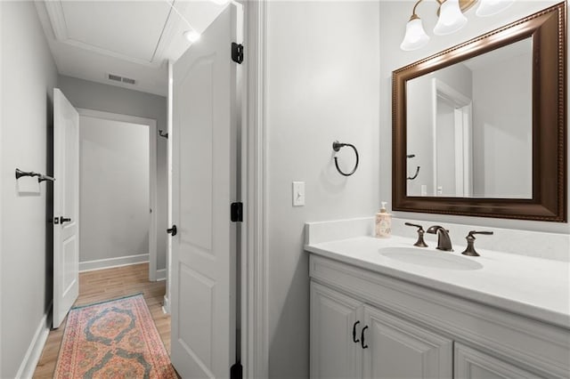 bathroom featuring baseboards, visible vents, wood finished floors, and vanity