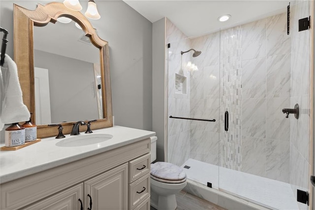 bathroom with vanity, toilet, and a shower stall