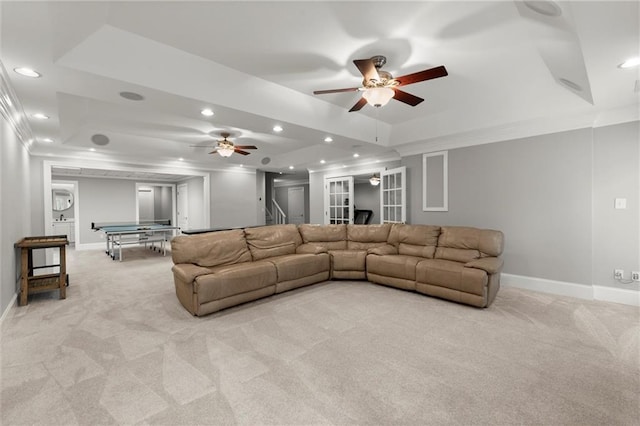 living room featuring recessed lighting, light carpet, crown molding, and a tray ceiling