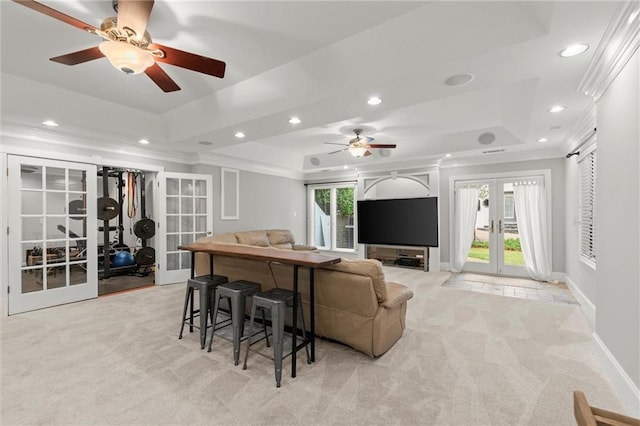 living room featuring recessed lighting, light colored carpet, a raised ceiling, a ceiling fan, and french doors