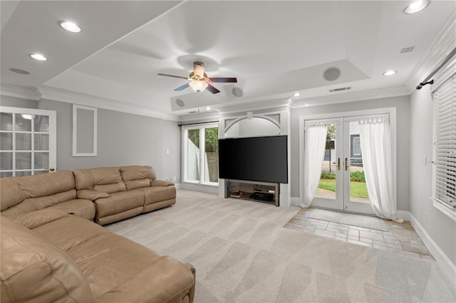 living area with a raised ceiling, french doors, visible vents, and baseboards