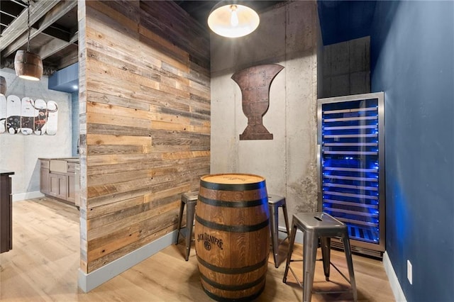 interior space featuring wood walls, wood finished floors, and wine cooler