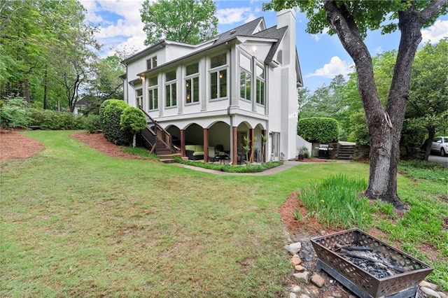 back of house featuring a yard, stucco siding, and a chimney