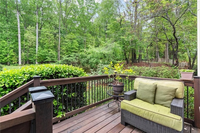 wooden deck featuring an outdoor hangout area and a view of trees