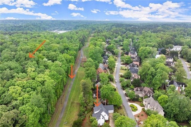 drone / aerial view featuring a residential view and a wooded view