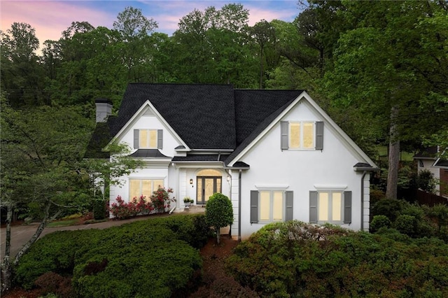 view of front of property with a chimney and stucco siding