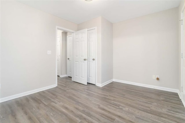 unfurnished bedroom featuring dark hardwood / wood-style floors and a closet