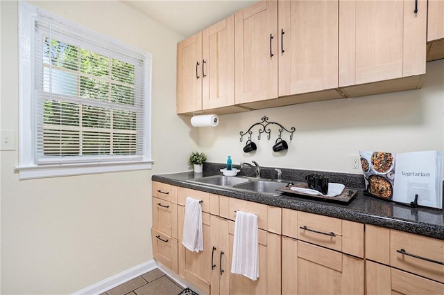 kitchen featuring sink, light tile patterned floors, and light brown cabinetry