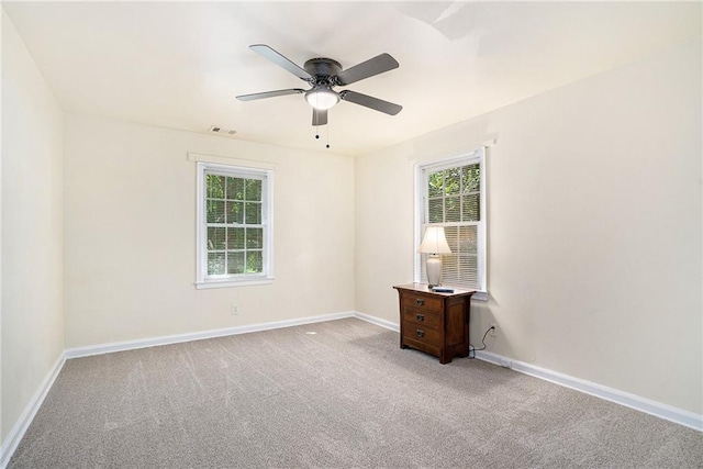 carpeted spare room with plenty of natural light and ceiling fan