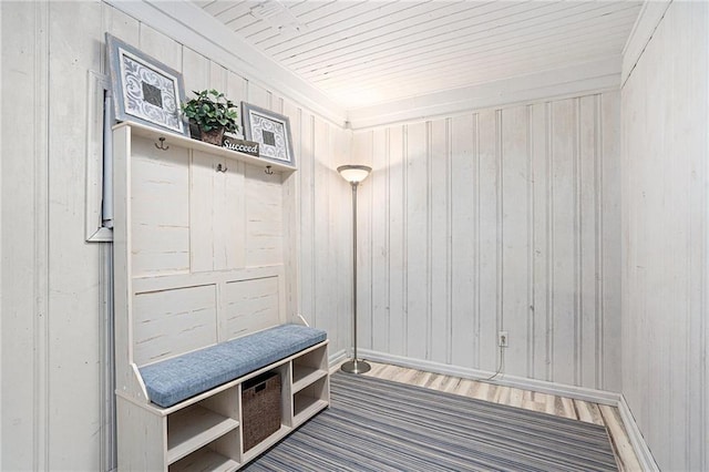 mudroom featuring wood-type flooring and wooden walls