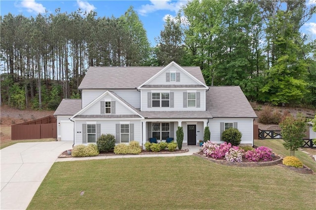 craftsman-style home with a shingled roof, fence, driveway, and a front yard