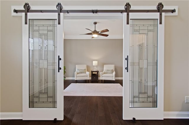 sitting room with baseboards, ceiling fan, a barn door, and wood finished floors
