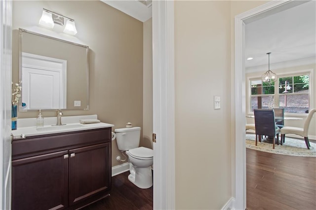 bathroom featuring baseboards, vanity, toilet, and wood finished floors