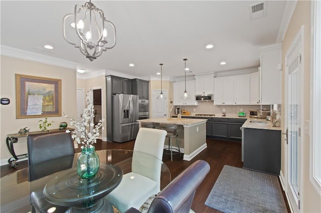 dining room featuring visible vents, crown molding, dark wood finished floors, an inviting chandelier, and recessed lighting