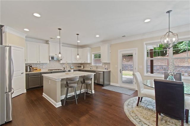 kitchen featuring a kitchen island, stainless steel appliances, decorative backsplash, and white cabinetry