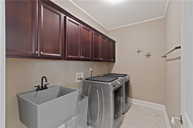 laundry area featuring independent washer and dryer, crown molding, cabinet space, a sink, and baseboards
