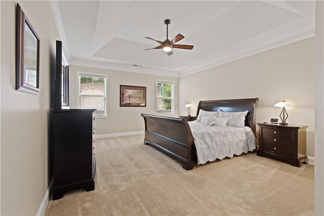 bedroom with crown molding, baseboards, light carpet, and a raised ceiling
