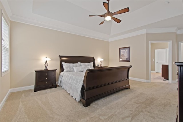 bedroom featuring crown molding, a raised ceiling, baseboards, and light carpet