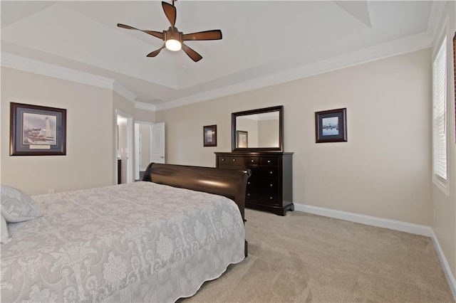 bedroom with ornamental molding, light carpet, baseboards, a tray ceiling, and a ceiling fan