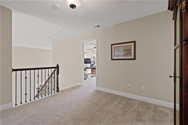 corridor with carpet flooring, baseboards, an upstairs landing, and visible vents