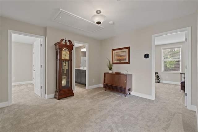 interior space with baseboards, attic access, and light carpet