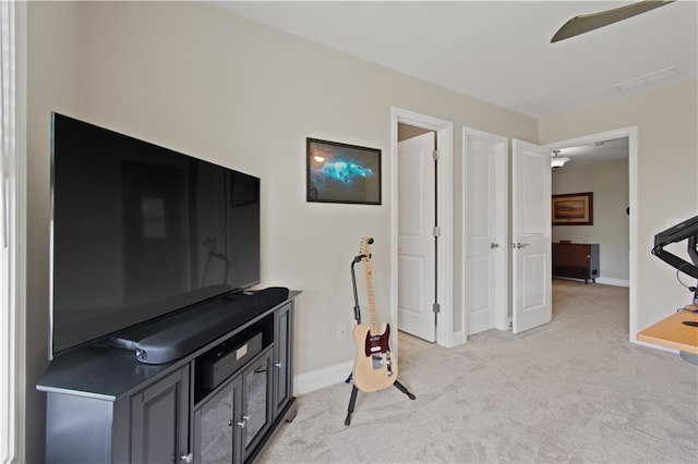 interior space featuring light colored carpet, baseboards, ceiling fan, and visible vents