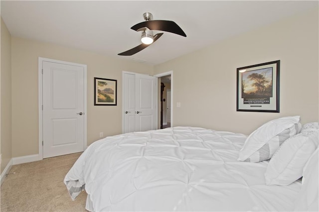 bedroom featuring a ceiling fan, baseboards, and light carpet