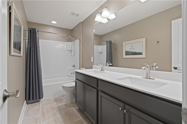 bathroom featuring visible vents, a sink, double vanity, and toilet