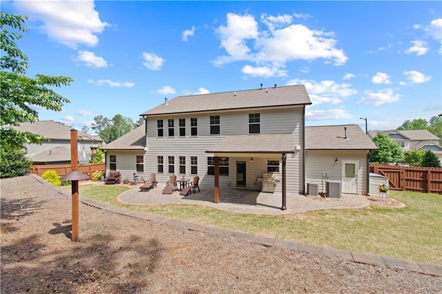 rear view of property featuring a lawn, a fenced backyard, a patio area, and central AC unit