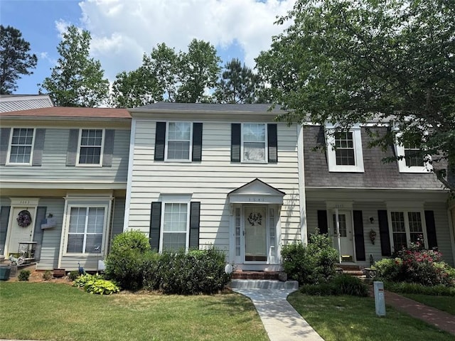 townhome / multi-family property featuring a front lawn