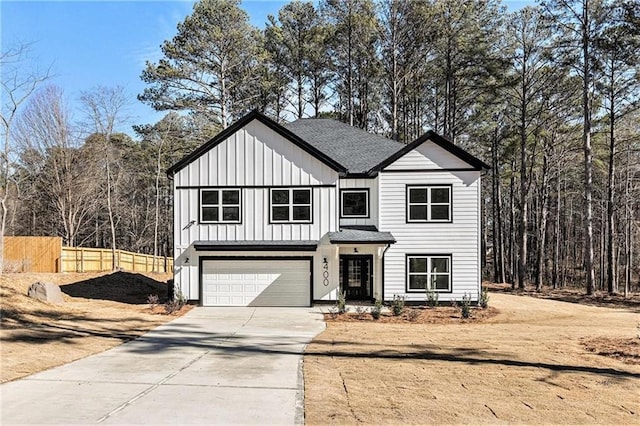400 Stone Lea Trce, Oxford, GA 30054 - view of front facade featuring fence, concrete driveway, board and batten siding, a garage, and a shingled roof