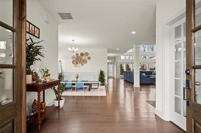 entryway with an inviting chandelier and dark hardwood / wood-style floors