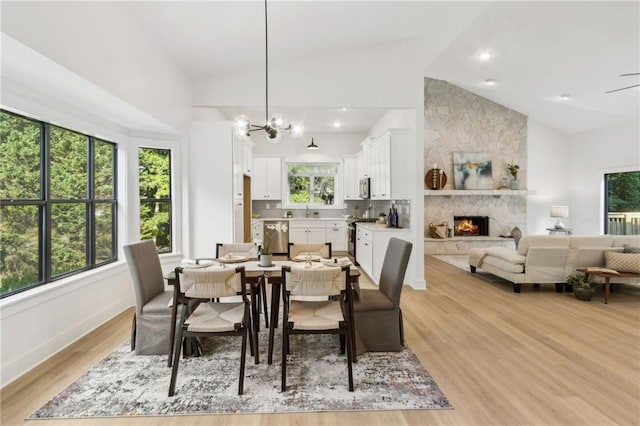 2010 Barnes Mill Rd, Marietta, GA 30062 - dining area featuring a stone fireplace, high vaulted ceiling, light wood-type flooring, and a chandelier