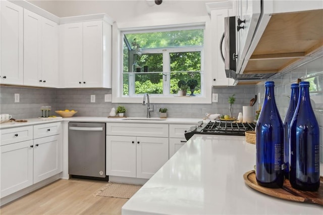 2010 Barnes Mill Rd, Marietta, GA 30062 - kitchen featuring dishwasher, light countertops, decorative backsplash, white cabinets, and light wood-style flooring