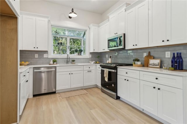 2010 Barnes Mill Rd, Marietta, GA 30062 - kitchen featuring stainless steel appliances, light wood-style floors, light countertops, and tasteful backsplash