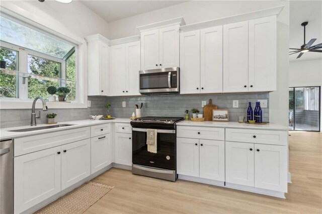 2010 Barnes Mill Rd, Marietta, GA 30062 - kitchen featuring appliances with stainless steel finishes, light countertops, decorative backsplash, and white cabinets