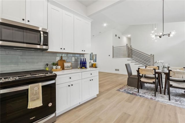 2010 Barnes Mill Rd, Marietta, GA 30062 - kitchen featuring stainless steel appliances, tasteful backsplash, light wood finished floors, white cabinets, and light countertops