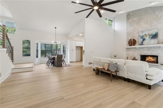 2010 Barnes Mill Rd, Marietta, GA 30062 - living room featuring stairway, light wood finished floors, a ceiling fan, a stone fireplace, and healthy amount of natural light
