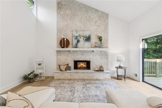 2010 Barnes Mill Rd, Marietta, GA 30062 - living area featuring wood finished floors, a stone fireplace, and vaulted ceiling
