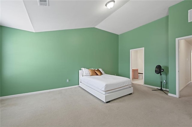 unfurnished bedroom featuring vaulted ceiling, connected bathroom, and light carpet