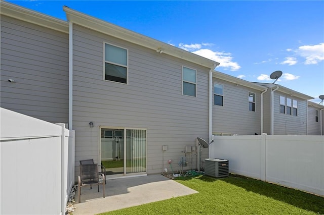 back of property featuring cooling unit, a lawn, and a patio area