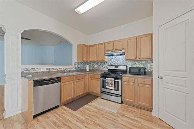 kitchen with appliances with stainless steel finishes, sink, backsplash, light brown cabinets, and light hardwood / wood-style flooring